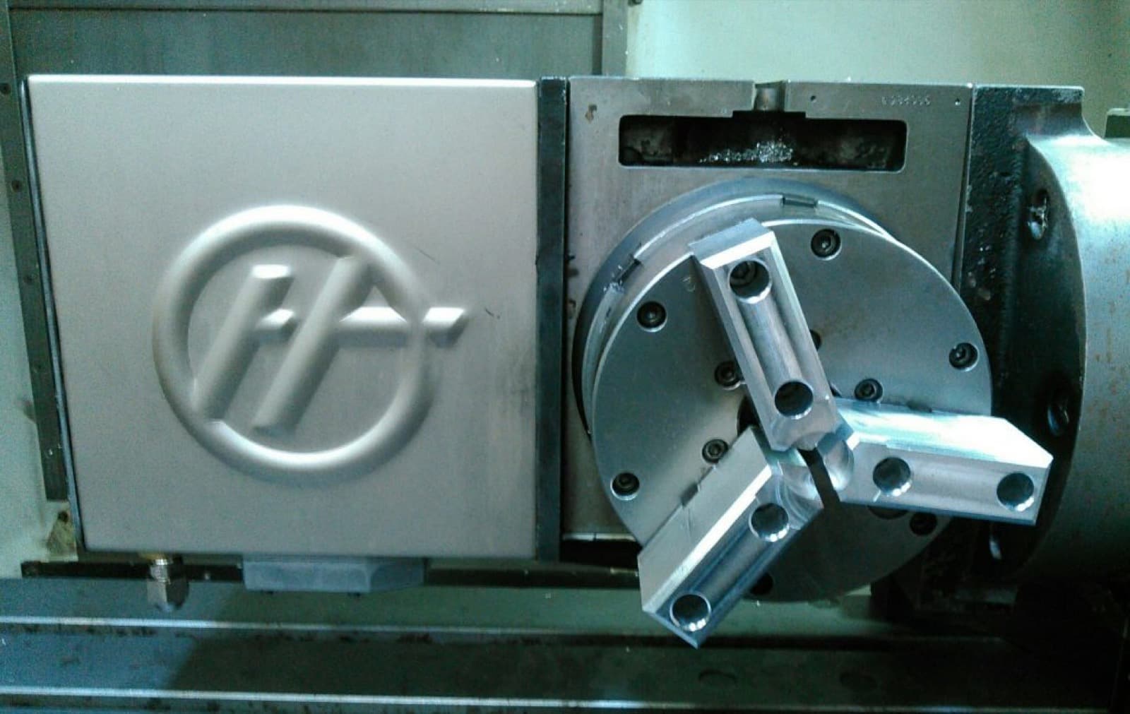Haas machining center with rotary chuck and machined Haas logo