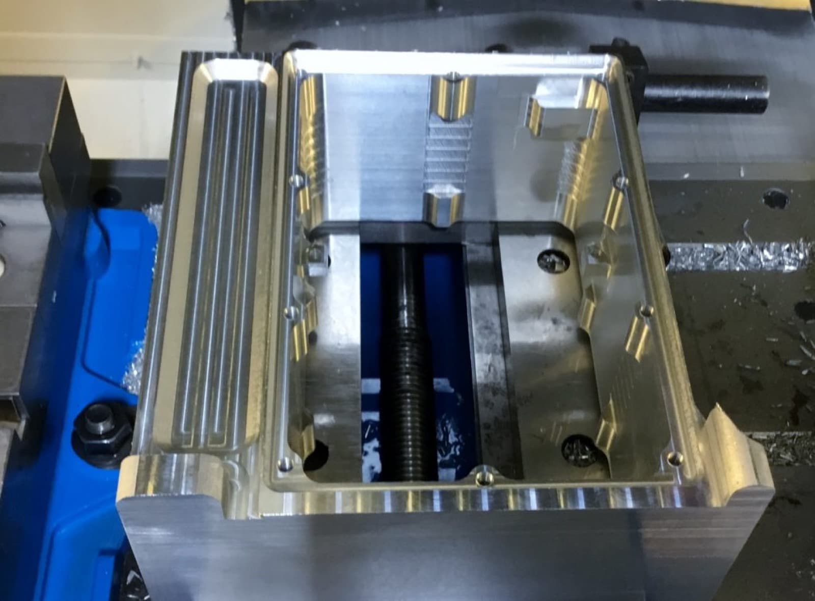 Aluminum part set up in a vise on a CNC machining center