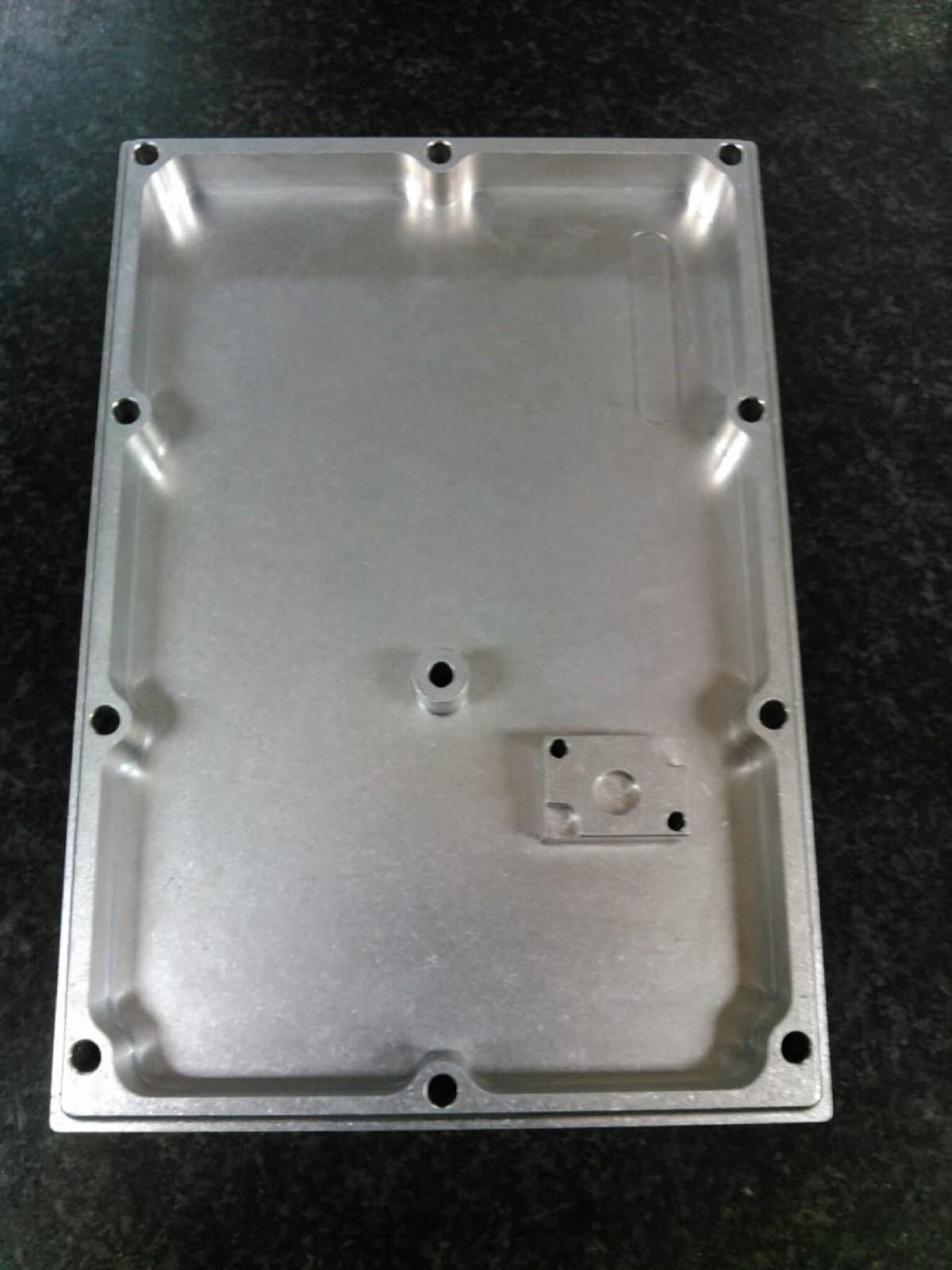 Machined aluminum top-plate enclosure with sealed pocket and bosses